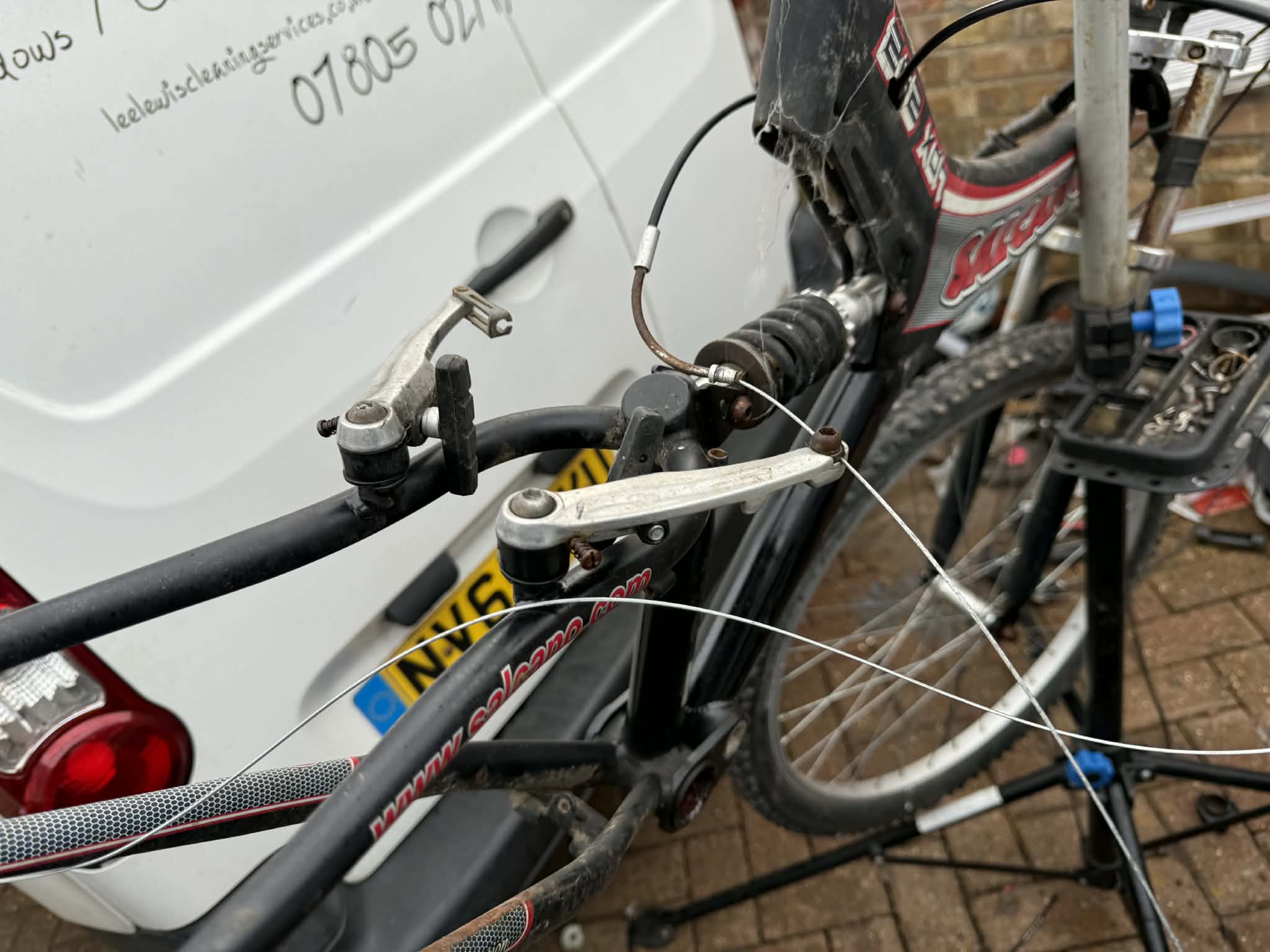 black road bike parked beside brown wooden wall